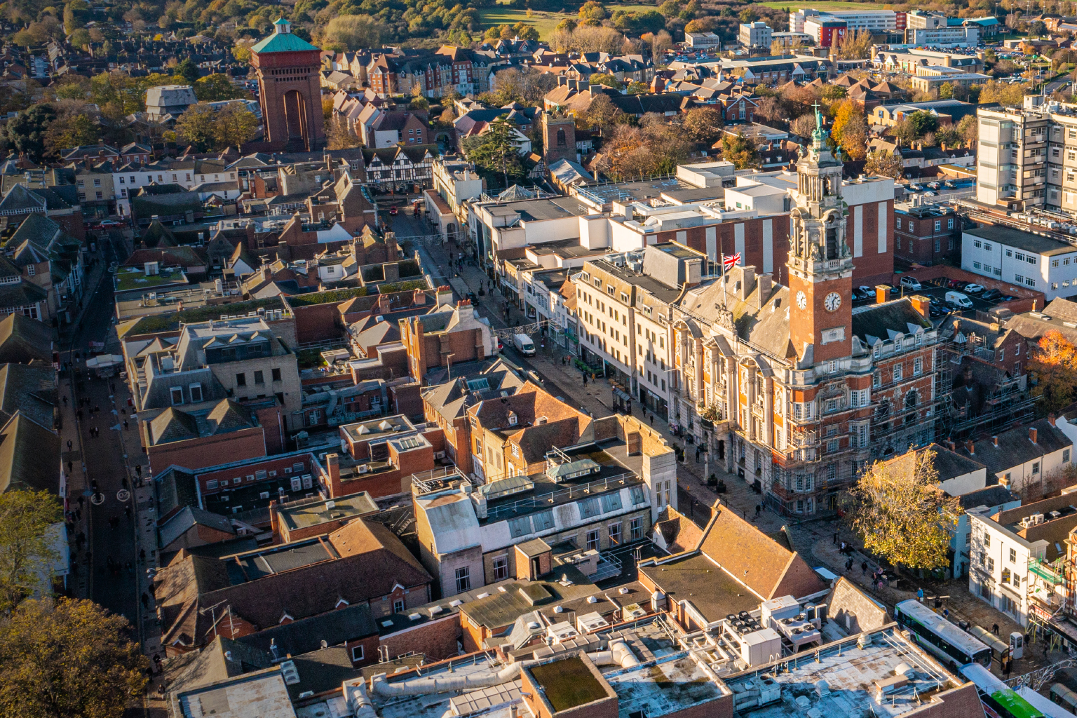 Aerial view of a town with red-brick buildings and a clock tower.