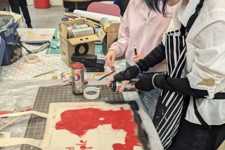 workshop with people painting bags