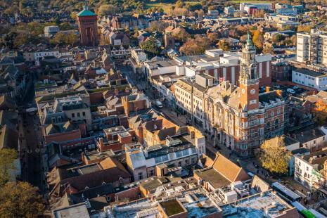 Aerial view of a town with red-brick buildings and a clock tower.